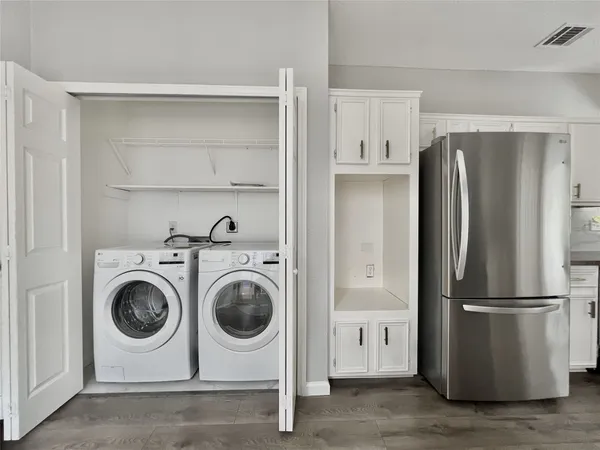 a view of a kitchen with a stove top oven a refrigerator and cabinets