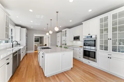 a large kitchen with stainless steel appliances and white cabinets