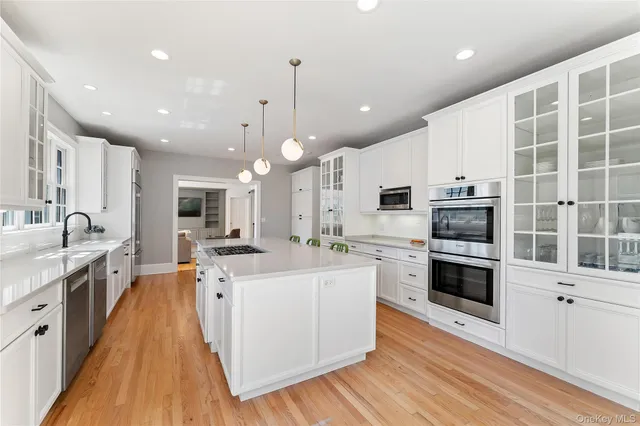 a large kitchen with stainless steel appliances and white cabinets