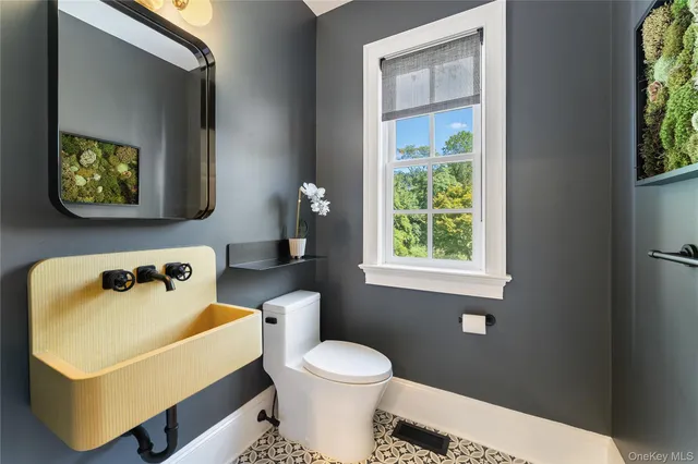 a bathroom with a sink a toilet and a window