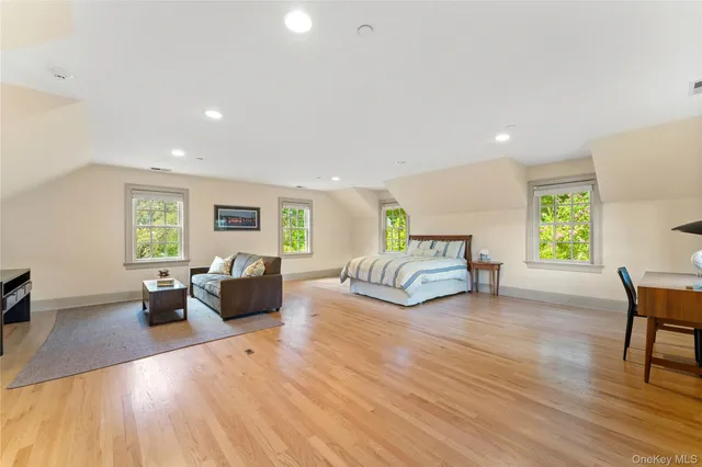 a spacious bedroom with a bed a couch and a window