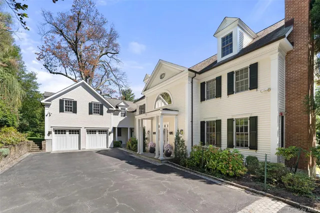 a view of a white house with large windows and a small yard