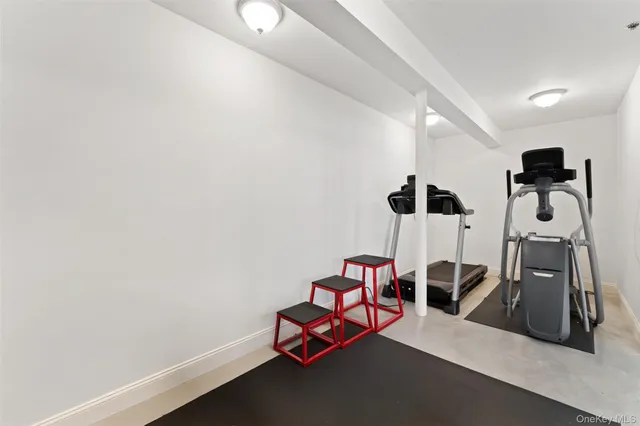 a room with gym equipment and wooden floor