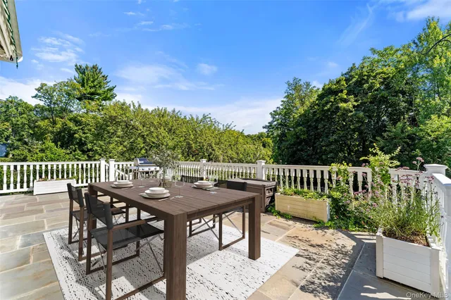 a balcony with wooden floor table and chairs