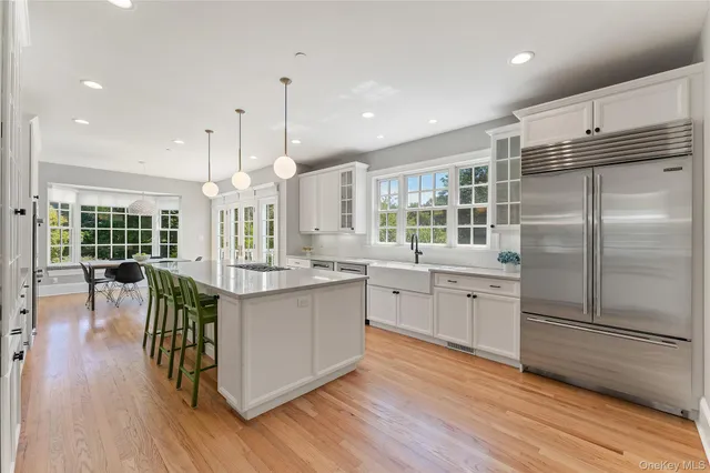 a kitchen with stainless steel appliances granite countertop a refrigerator a stove a sink and a wooden floors