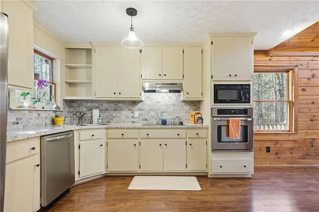 a kitchen with white cabinets sink and dishwasher