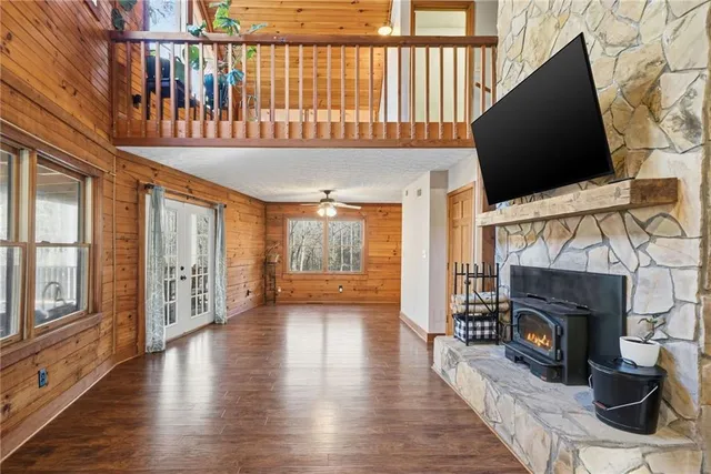 a view of an empty room with wooden floor fireplace and a window