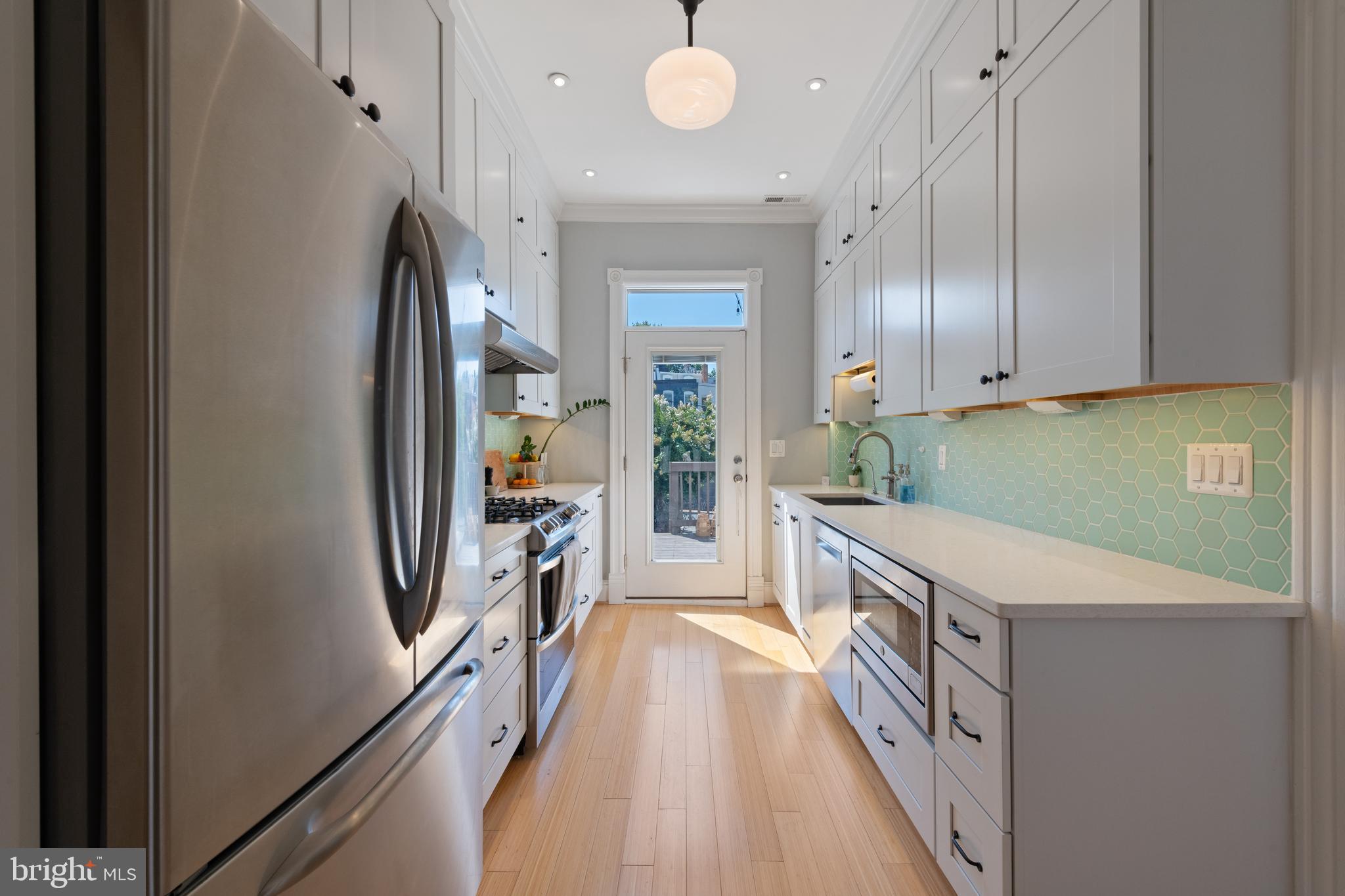 21 V Street Northeast Washington, DC 20002 - Photo 11 of 32 a kitchen with granite countertop a refrigerator a sink dishwasher a stove and a refrigerator with wooden floor