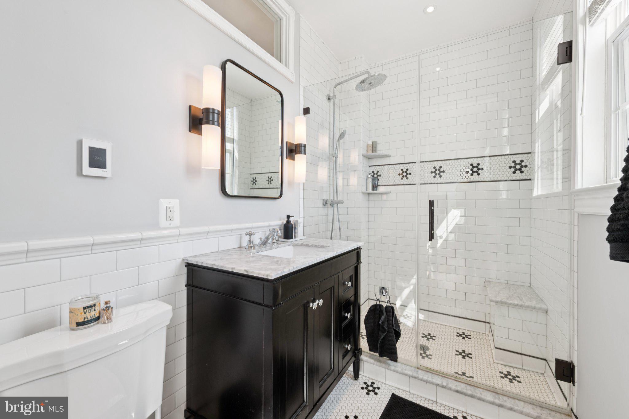 21 V Street Northeast Washington, DC 20002 - Photo 24 of 32 a bathroom with a sink toilet a mirror and shower