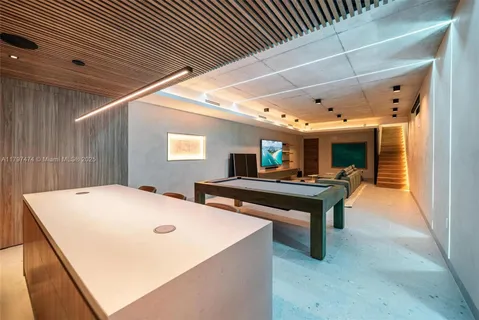 a room with pool table and windows