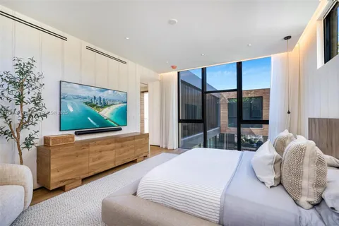 a bedroom with bed couches and flat screen tv