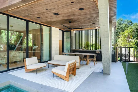 a living room with patio furniture and a wooden floor