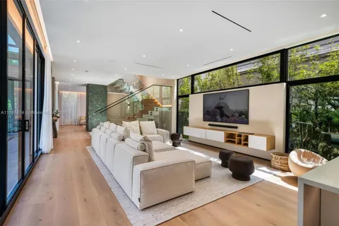 a living room with furniture a flat screen tv and a large window