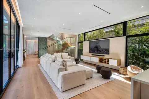 a living room with furniture a flat screen tv and a large window