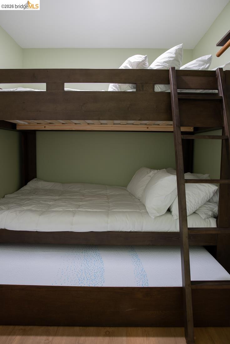 18399 Lime Kiln Road Sonora, CA 95370 - Photo 16 of 36 Dark wood-finish bunk beds featuring a ladder and a trundle bed, set against light green walls
