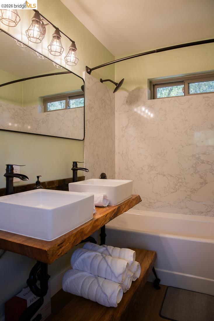 18399 Lime Kiln Road Sonora, CA 95370 - Photo 23 of 36 Dual vessel sinks with dark bronze fixtures set on a live-edge wood vanity