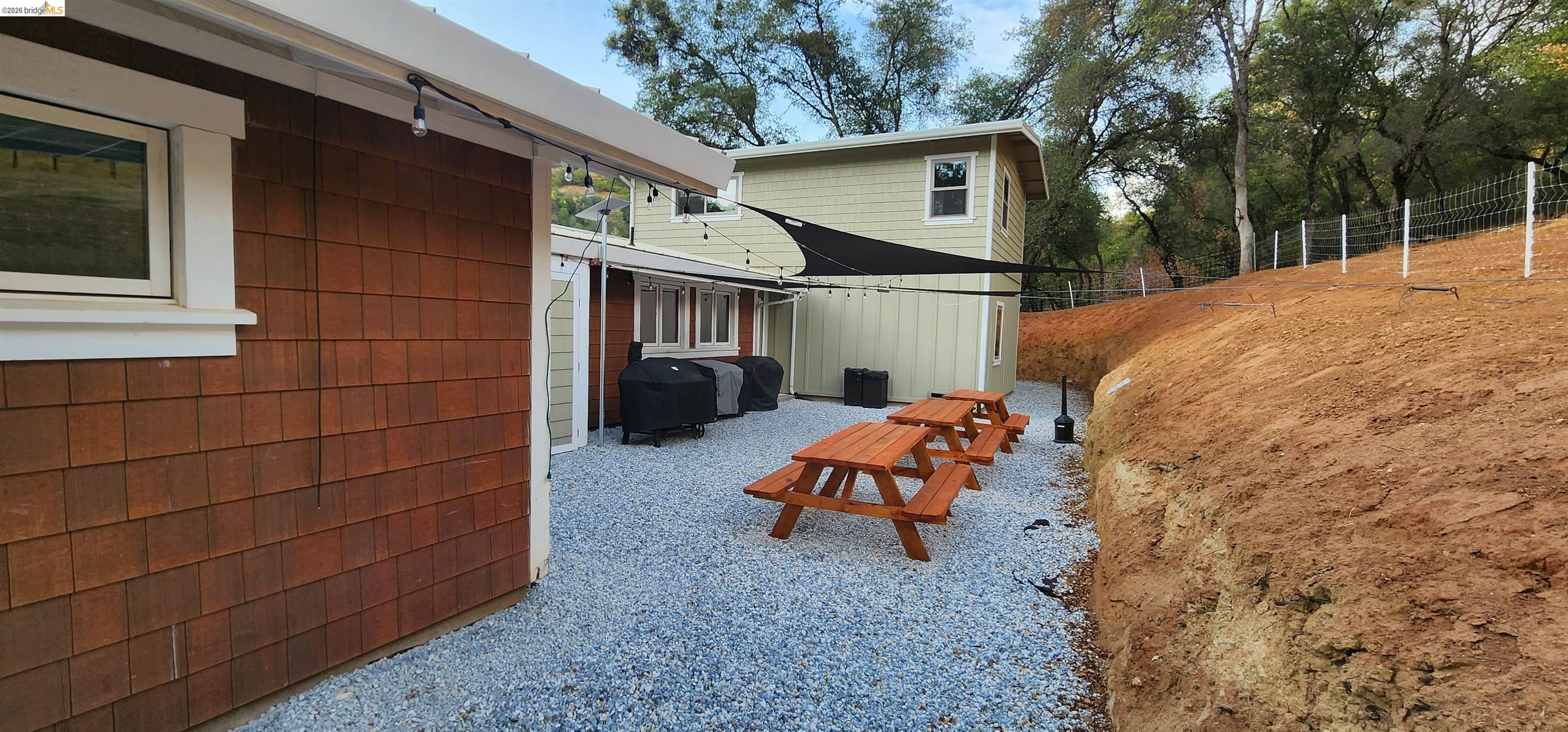 18399 Lime Kiln Road Sonora, CA 95370 - Photo 29 of 36 Gravel patio area featuring multiple picnic tables and string lighting