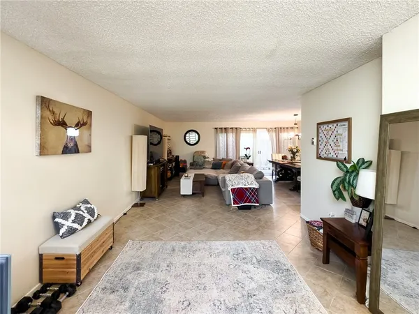 a room with a baby bed a desk and chair with wooden floor