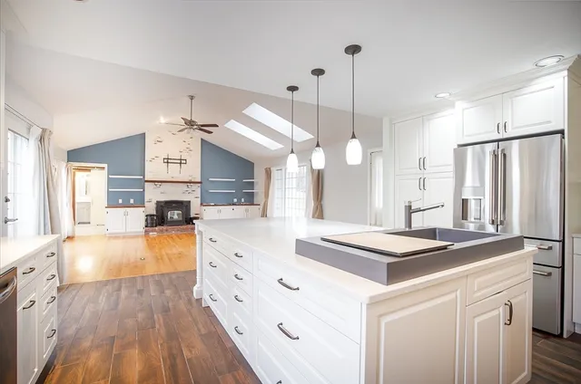 a kitchen with stainless steel appliances kitchen island granite countertop a sink a stove and a refrigerator