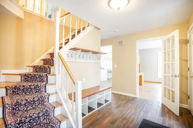 a large white kitchen with wooden floor and stainless steel appliances