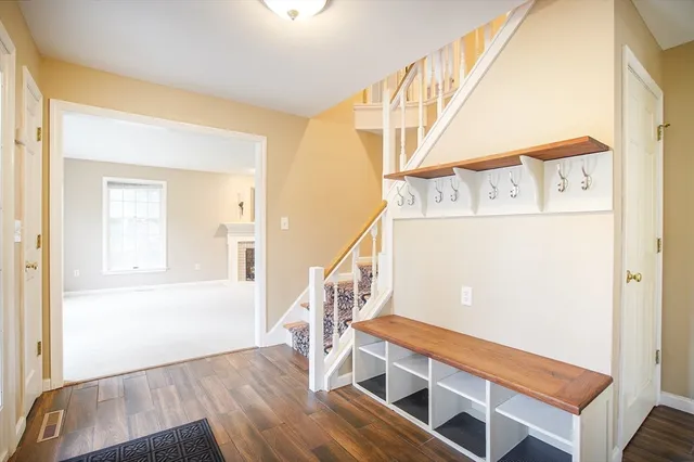 a view of a livingroom with a fireplace a ceiling fan and wooden floor