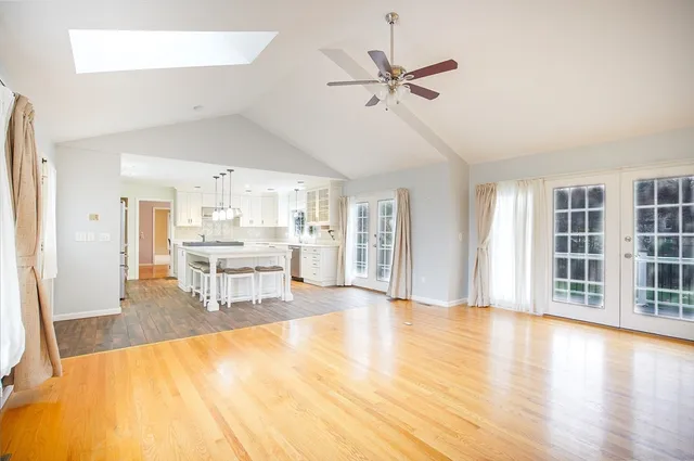 a view of an empty room with window and a kitchen