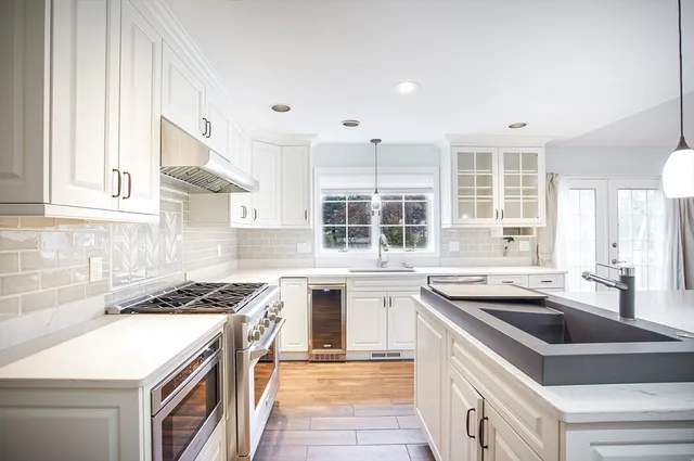 a kitchen with stainless steel appliances granite countertop a sink stove and cabinets
