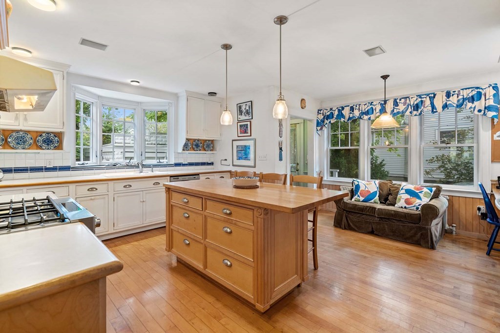 47 Stearns Street Newton, MA 02459 - Photo 16 of 32 a kitchen with kitchen island granite countertop a stove a sink a refrigerator and couches with wooden floor