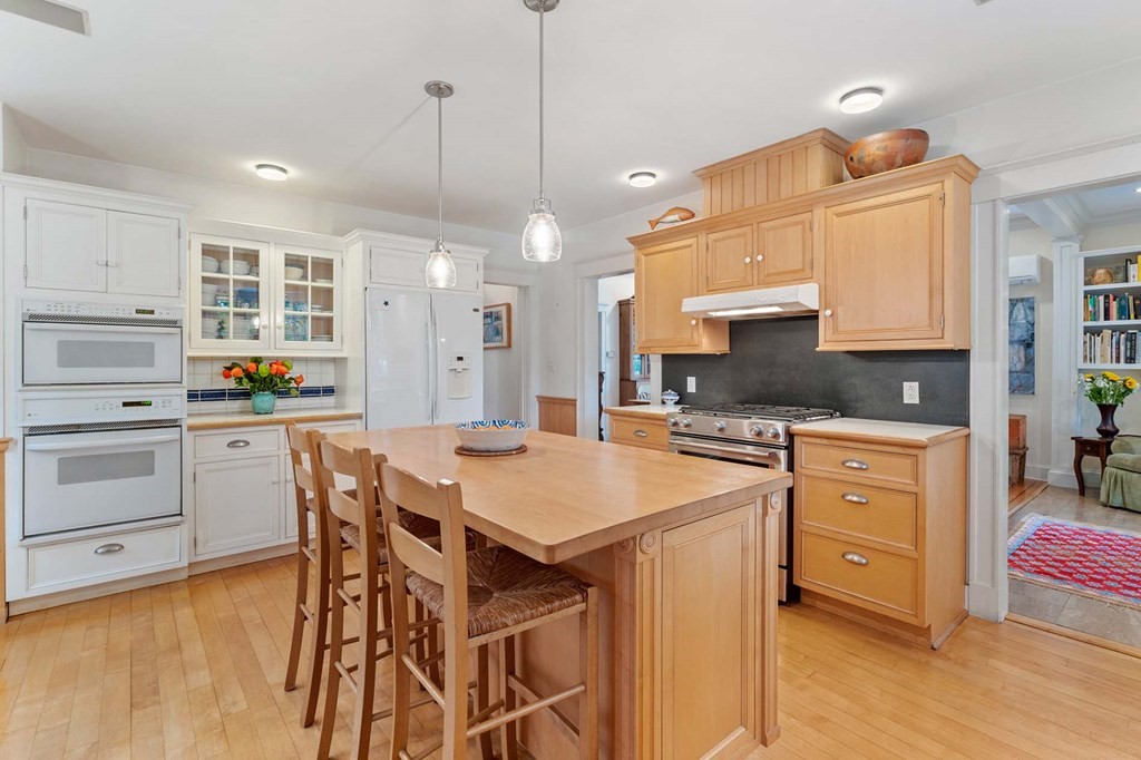 47 Stearns Street Newton, MA 02459 - Photo 18 of 32 a kitchen with a table chairs stove a sink dishwasher a dining table and chairs with wooden floor
