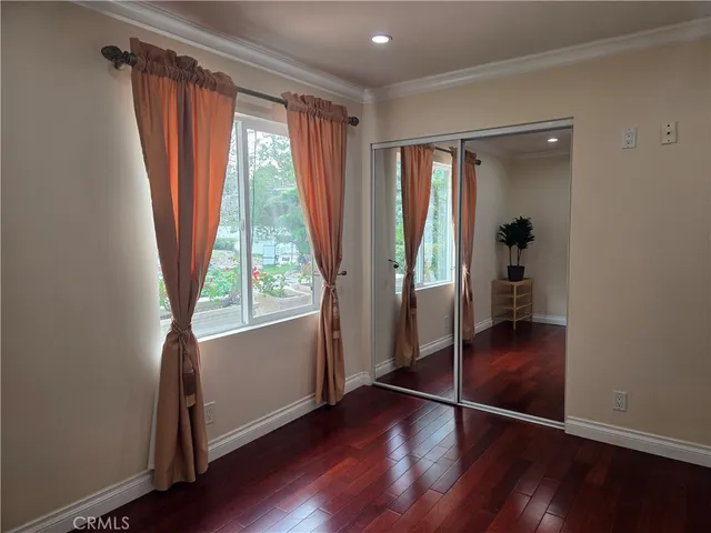 an empty room with wooden floor and a window