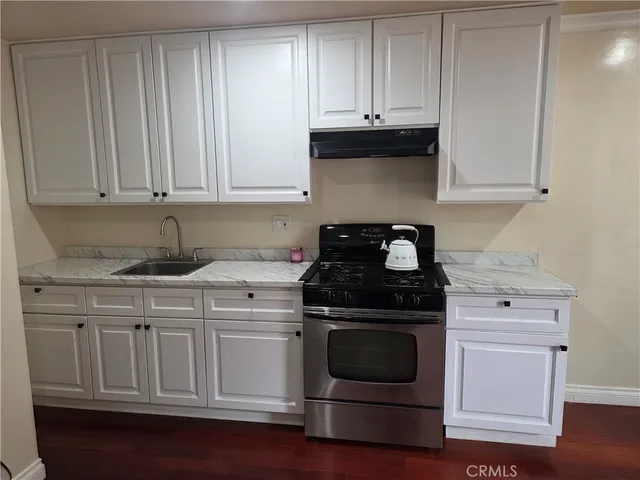 a kitchen with granite countertop white cabinets and stainless steel appliances