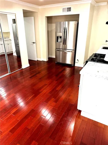 a view of empty room with wooden floor