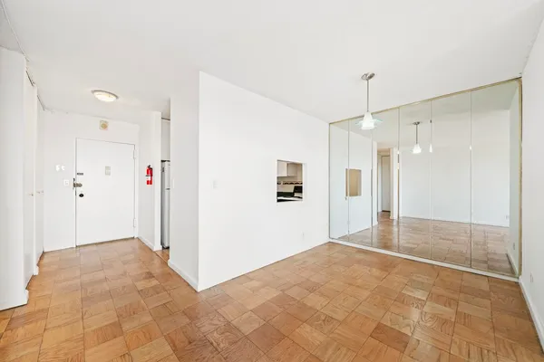 a view of an empty room with a window and bathroom