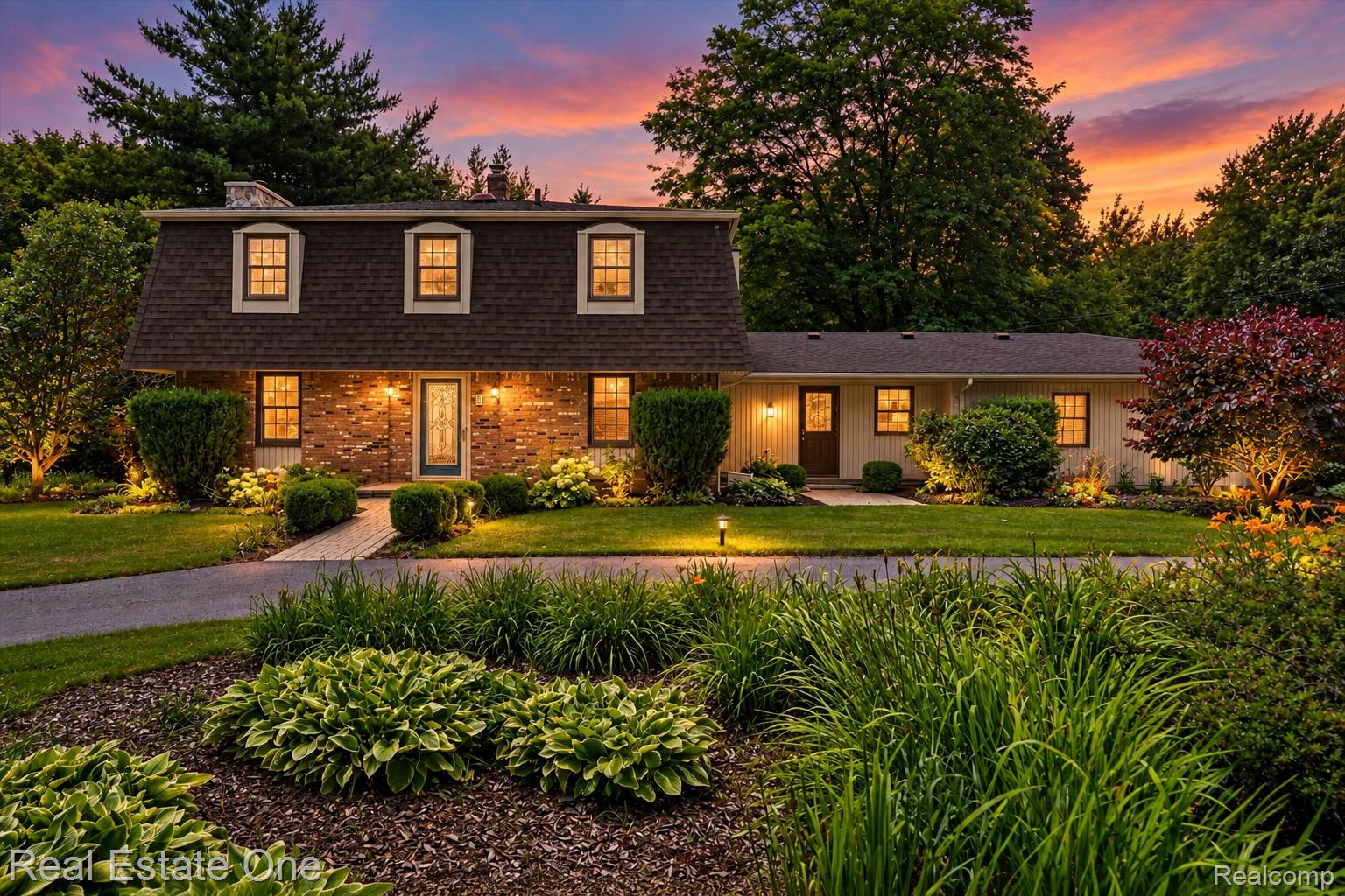 Dutch Colonial with a circular driveway and many flower gardens to enjoy. 