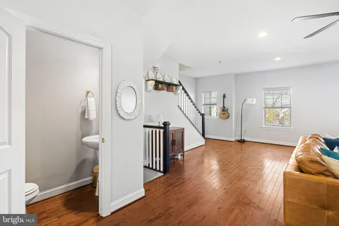 a view of a livingroom with wooden floor and stairs
