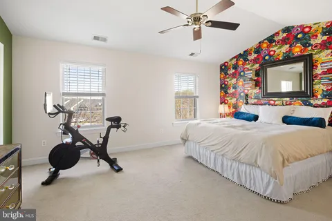 a bedroom with a bed gym equipment and a flat screen tv