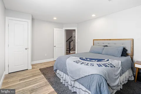 a bedroom with a large bed and wooden floor