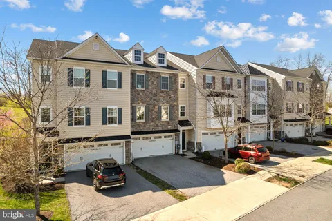 a view of a white house with large windows and couches chairs