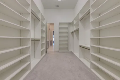 a view of walk in closet with empty racks