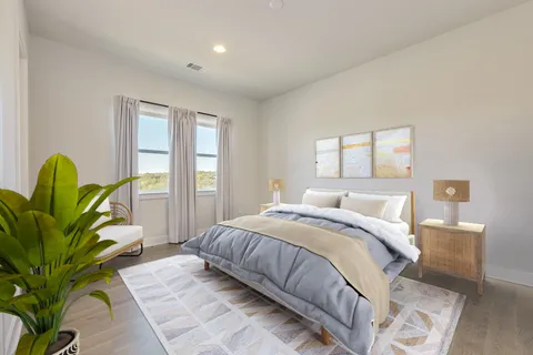 a bedroom with a bed with furniture and a potted plant