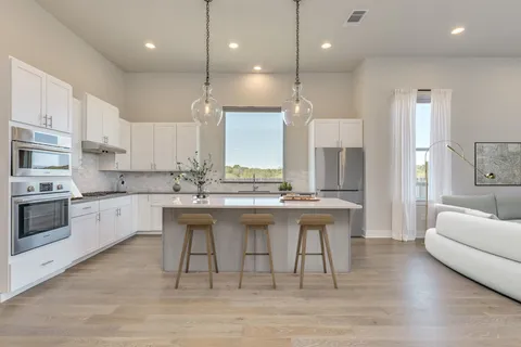 a kitchen with a sink cabinets and wooden floor