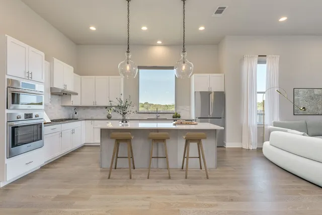 a kitchen with stainless steel appliances white cabinets and a sink