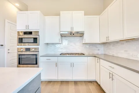 a kitchen with stainless steel appliances white cabinets and a sink