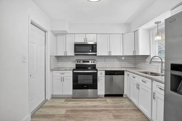 a kitchen with cabinets stainless steel appliances and a counter space