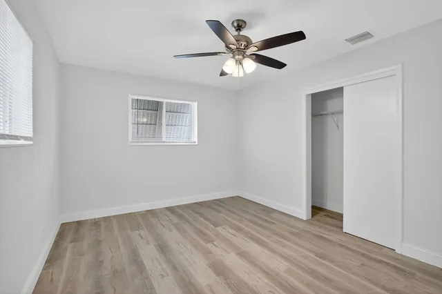 a view of a big room with wooden floor and windows