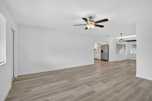 a view of a room with wooden floor and a ceiling fan