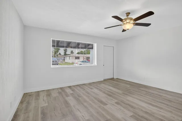 a view of empty room with wooden floor