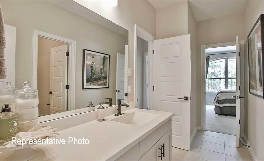 2845 Taylor Trail Corinth, TX 76210 - Photo 12 of 14 Bathroom vanity featuring a single basin, dark bronze faucet, and a large wall-mounted mirror