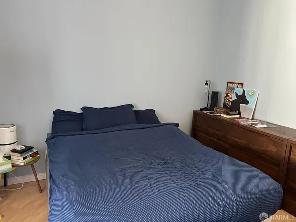 a bedroom with a bed and wooden floor