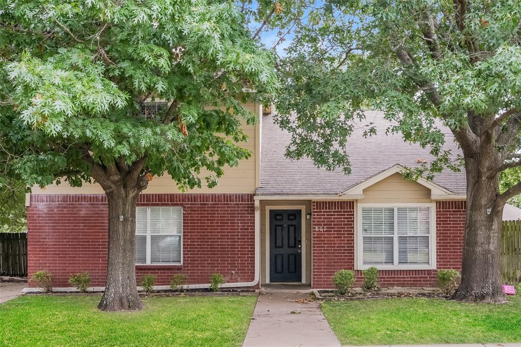 front view of a house with a yard and an trees